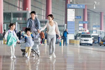 欢乐家庭在机场推着行李手牵手高质量素材