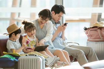 快乐家庭坐在机场候机厅里水平构图写实场景