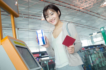 商务女士在机场使用自动售票机护照摄影