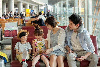 快乐家庭坐在机场候机厅里旅行者高端镜头