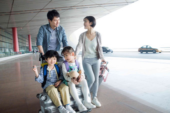 欢乐家庭在机场推着行李四个人清晰素材