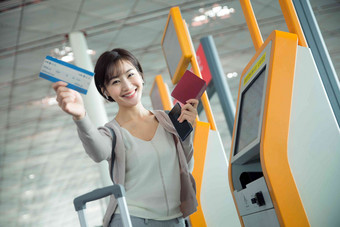 商务女士在机场使用自动售票机售票机高质量摄影图