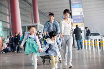 欢乐家庭在机场推着行李青年人摄影图