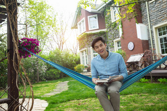 青年男人在院子里看书
