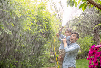 快乐父子在院子里浇水摄影高清镜头