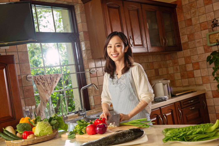 青年女人在厨房里做饭人写实摄影图