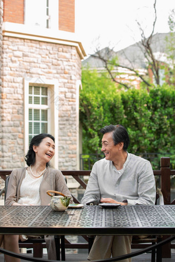 老年夫妇坐在院子里喝茶