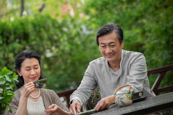 老年夫妇坐在院子里<strong>喝</strong>茶