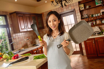 青年女人在厨房里做饭