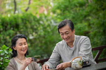 老年夫妇坐在院子里喝茶