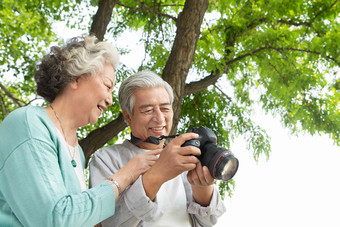 老年夫妇在公园里拍照树氛围素材
