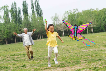 爷爷带着孙女在公园里<strong>放风筝</strong>