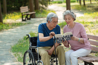 老年夫妇坐在公园里<strong>看书看书</strong>氛围摄影