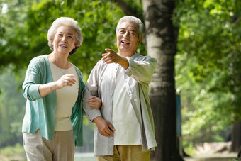 老年夫妇在公园里散步伸手指高清图片