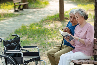老年夫妇<strong>坐在公园里</strong>看书