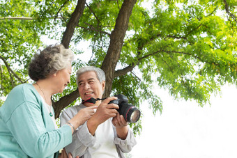 老年夫妇在公园里拍照彩色图片影相