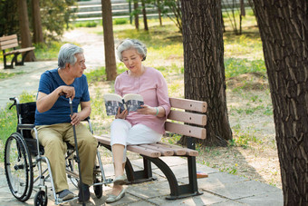 老年夫妇坐在公园里看书