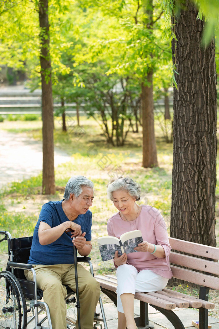 老年夫妇坐在公园里看书老年女人高质量图片