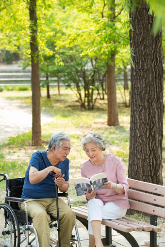 老年夫妇<strong>坐在公园里</strong>看书