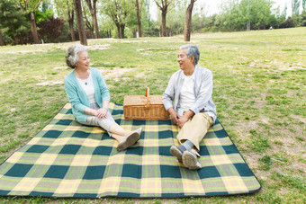 老年夫妇坐在公园草地上爱写实照片