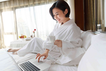 年轻女人在酒店房间里使用电脑