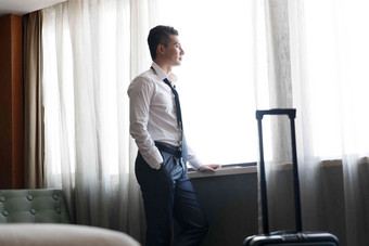 青年男士站在酒店房间里
