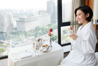 年轻女人在酒店房间里喝咖啡