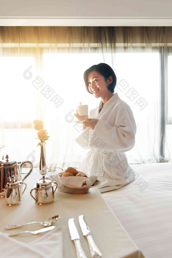 年轻女人在酒店房间里喝咖啡