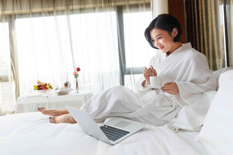年轻女人在酒店房间里使用电脑