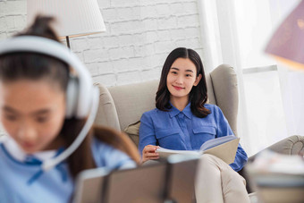 青年女人在家陪伴孩子学习