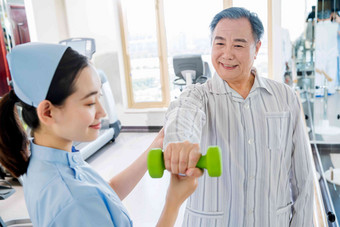 女护士协助病人康复锻炼