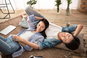 快乐情侣躺在地毯上享受午后时光爱氛围摄影