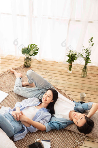 快乐情侣躺在地毯上享受午后时光