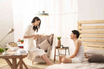 卧室里年轻的妻子坐在桌子上和丈夫聊天软垫氛围场景