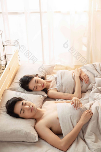 年轻情侣躺在床上睡觉柔和拍摄