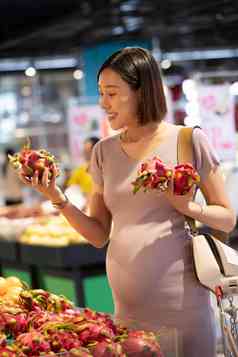 孕妇在超市挑选火龙果