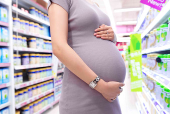 孕妇在超市购物货架写实场景