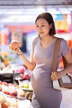 孕妇在超市挑选水果