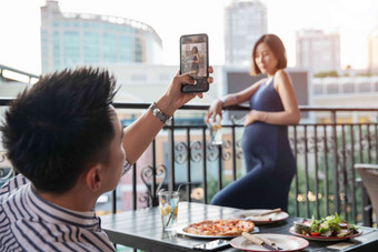 青年夫妇在餐厅用手机照相