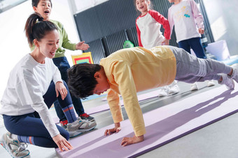 东方儿童在教练的指导下进行体能训练运动摄影图