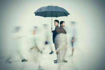 拿着<strong>雨伞</strong>的商务男女站在人群中