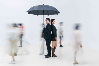 拿着<strong>雨伞</strong>的商务男女站在人群中
