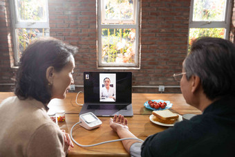 老年夫妇使用笔记本电脑在线看医生老年伴侣高清摄影图