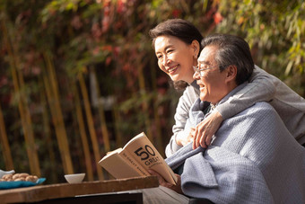 幸福的老年夫妇在户外看书看书写实影相