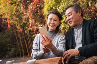老年夫妇在庭院使用手机交流清晰照片