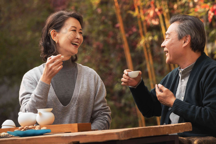 快乐的老年夫妇在庭院内品茶陪伴高清镜头