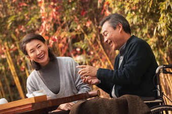 快乐的老年夫妇在庭院内品茶陪伴高清摄影图