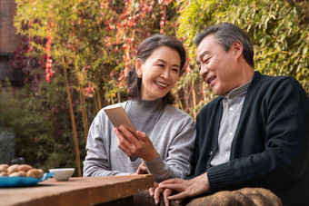 老年夫妇在庭院使用手机欢乐高质量图片