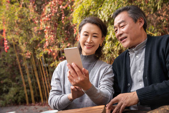 老年夫妇在庭院使用手机幸福清晰相片