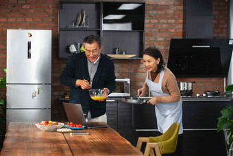 老年夫妇在厨房创新菜肴幸福拍摄